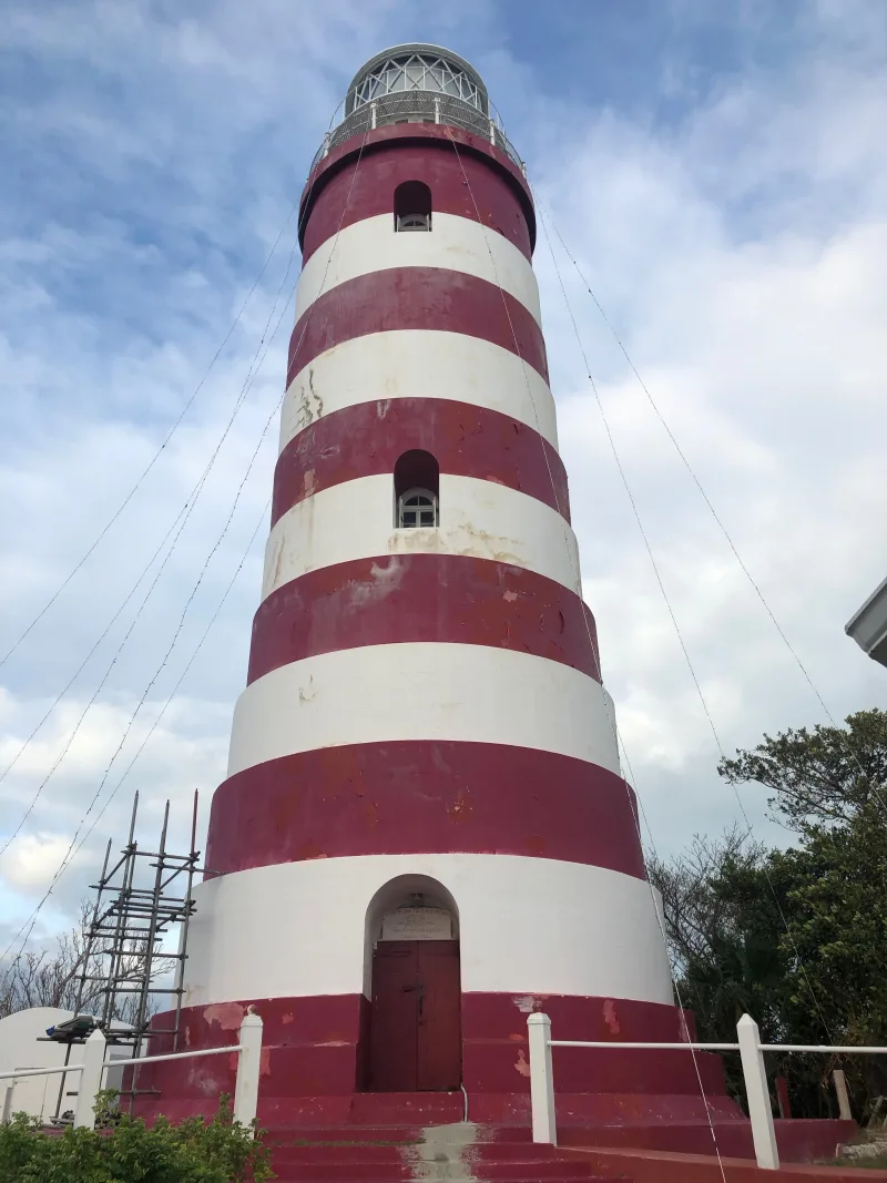 The red-and-white candy-striped Elbow Reef Lighthouse above Hope Town harbour, Elbow Cay, Abaco