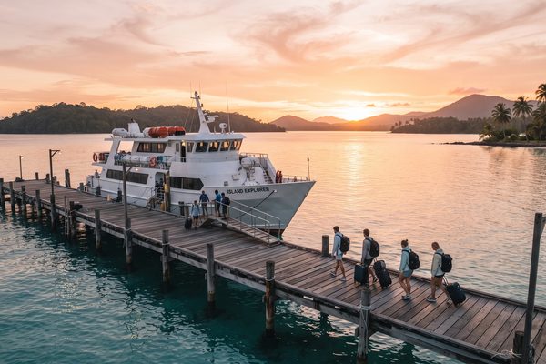 White ferry at a tropical pier in golden sunrise light